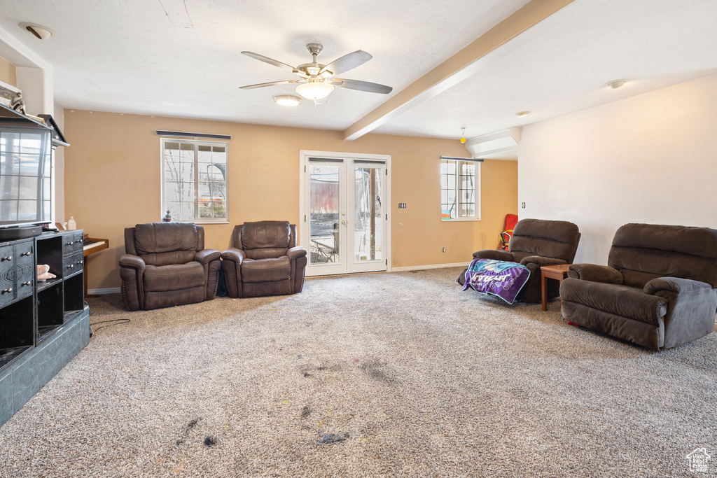 Living room featuring plenty of natural light, ceiling fan, and light colored carpet