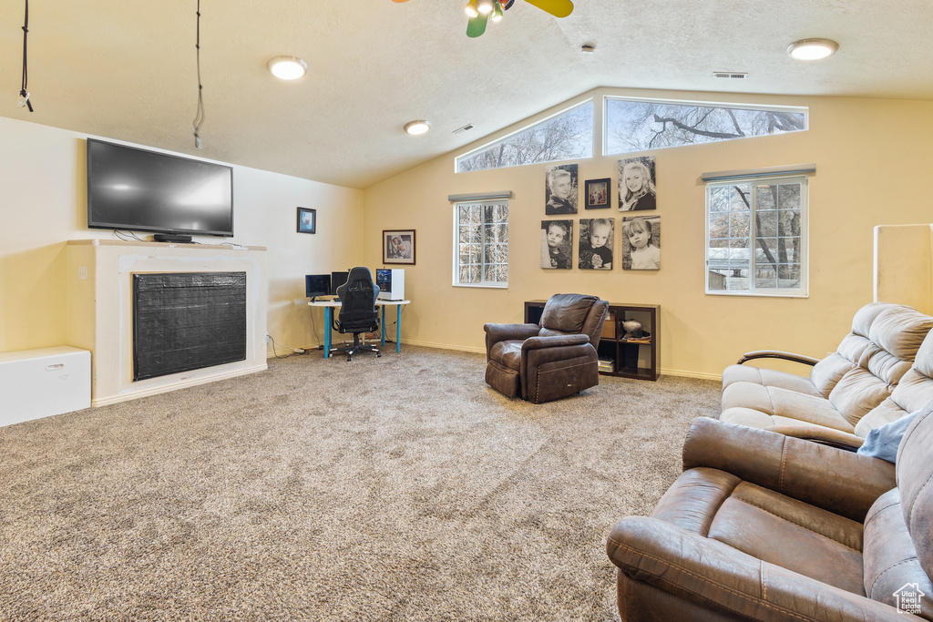 Living room with ceiling fan, light carpet, and lofted ceiling