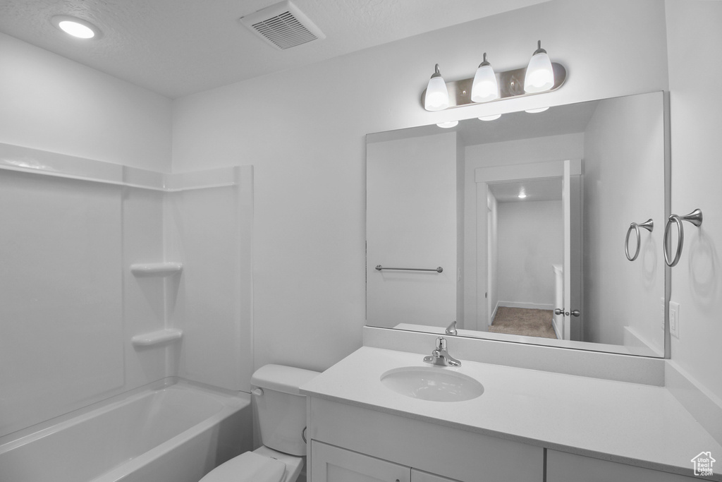Full bathroom featuring vanity, toilet, washtub / shower combination, and a textured ceiling
