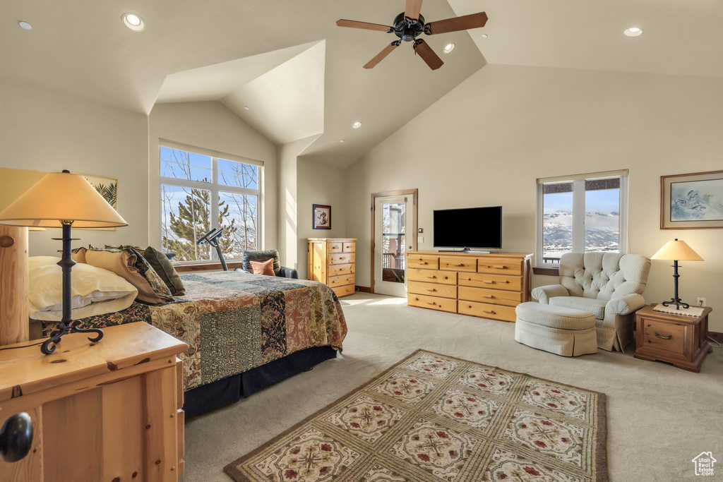 Carpeted bedroom featuring high vaulted ceiling, ceiling fan, and multiple windows