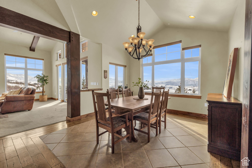 Dining space featuring plenty of natural light, light carpet, a notable chandelier, and a mountain view