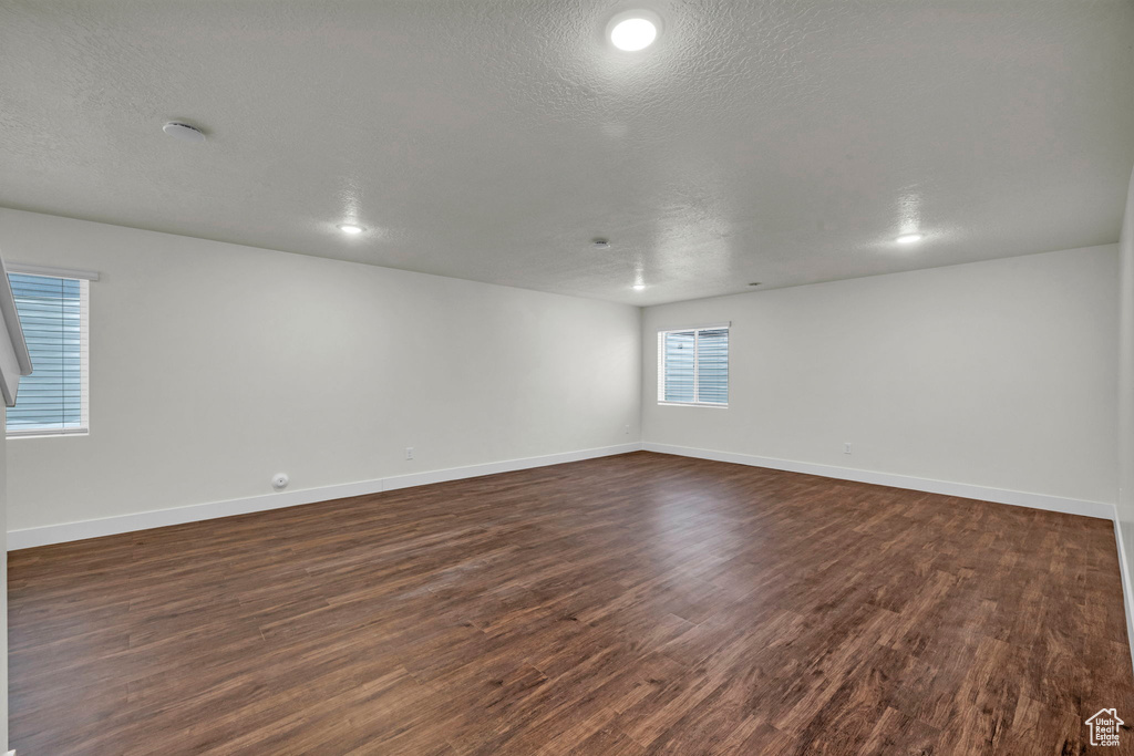 Unfurnished room with dark wood-type flooring and a textured ceiling