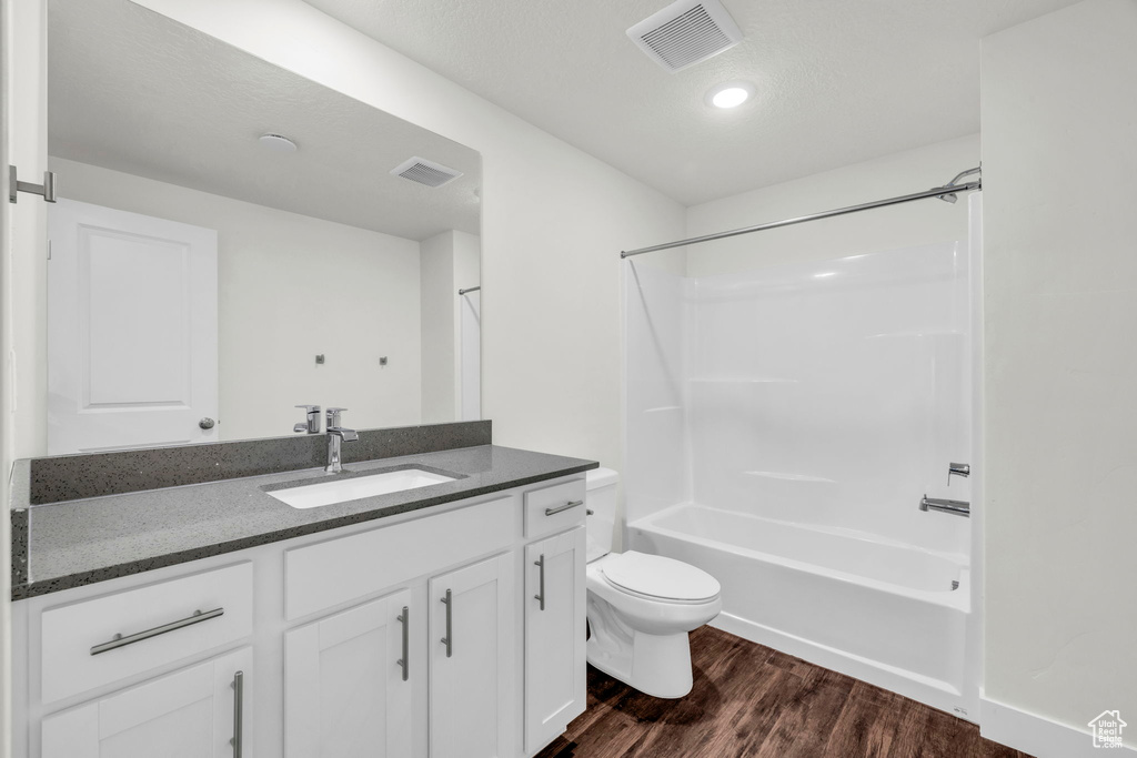 Full bathroom with shower / bathing tub combination, vanity, toilet, and wood-type flooring