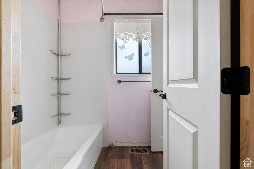 Bathroom featuring hardwood / wood-style floors and bathing tub / shower combination