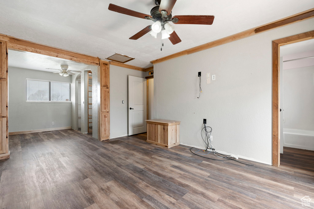 Unfurnished room featuring crown molding, ceiling fan, and dark hardwood / wood-style flooring