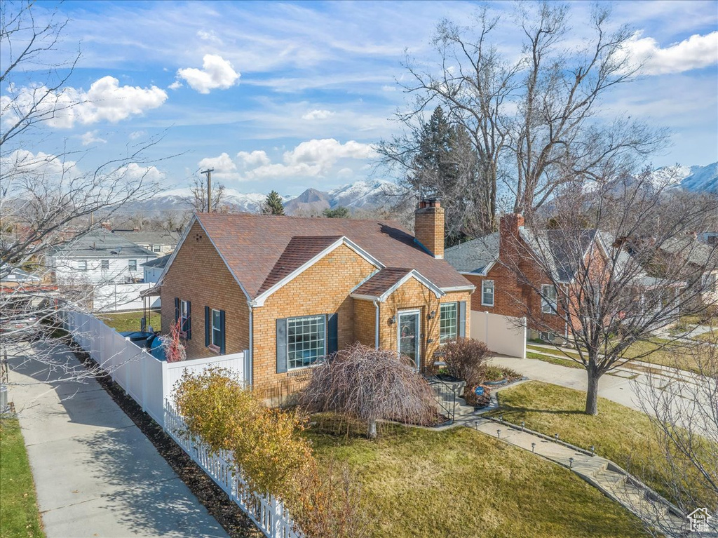 Single story home featuring a mountain view and a front yard