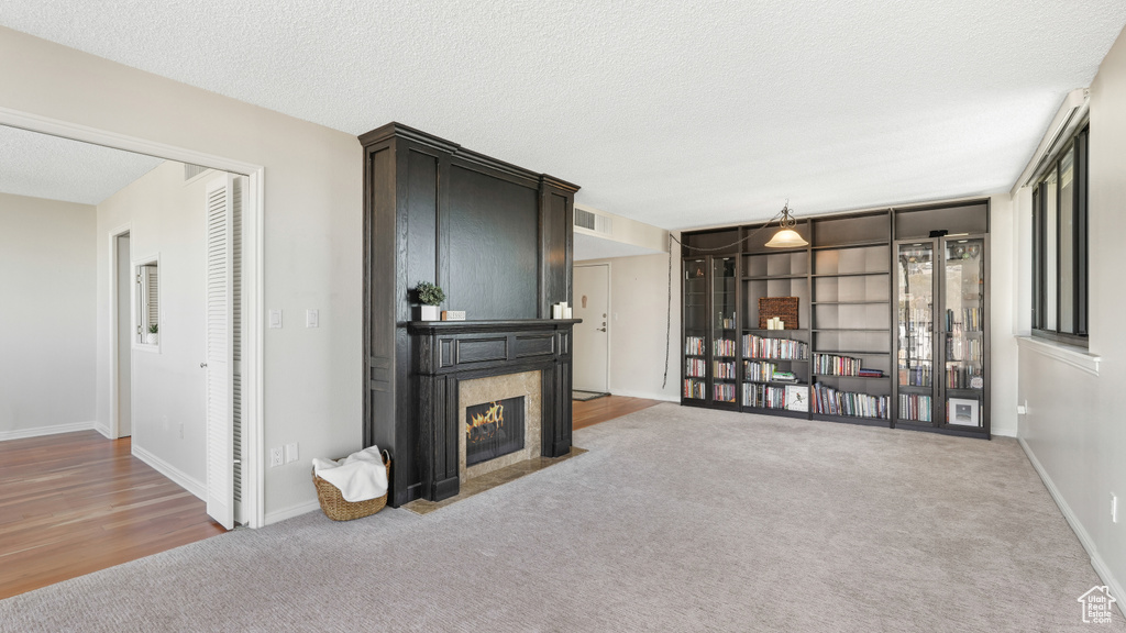 Carpeted living room with a tile fireplace and a textured ceiling
