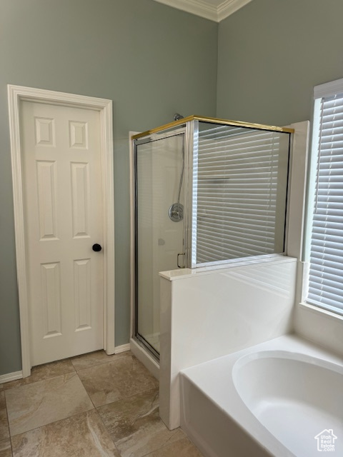 Bathroom with plenty of natural light, crown molding, tile flooring, and shower with separate bathtub
