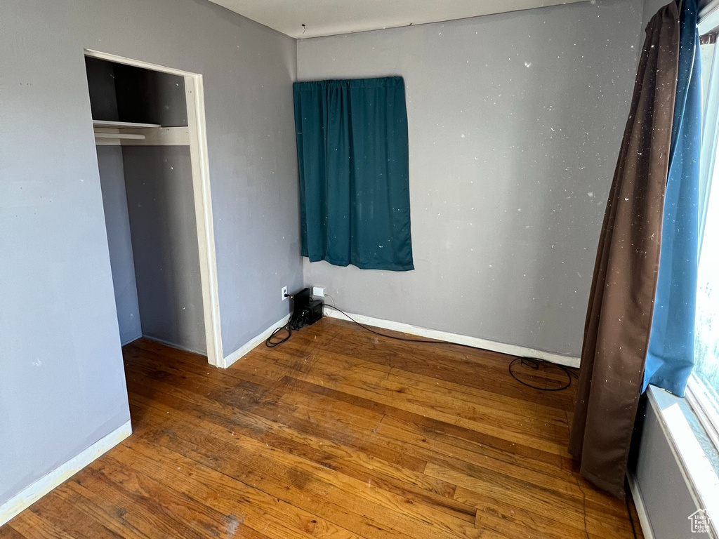 Unfurnished bedroom featuring dark wood-type flooring and a closet
