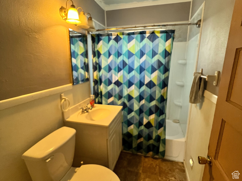 Full bathroom with tile flooring, toilet, crown molding, oversized vanity, and shower / bath combo