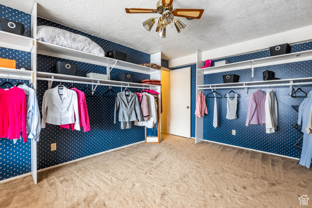 Spacious closet featuring light colored carpet and ceiling fan