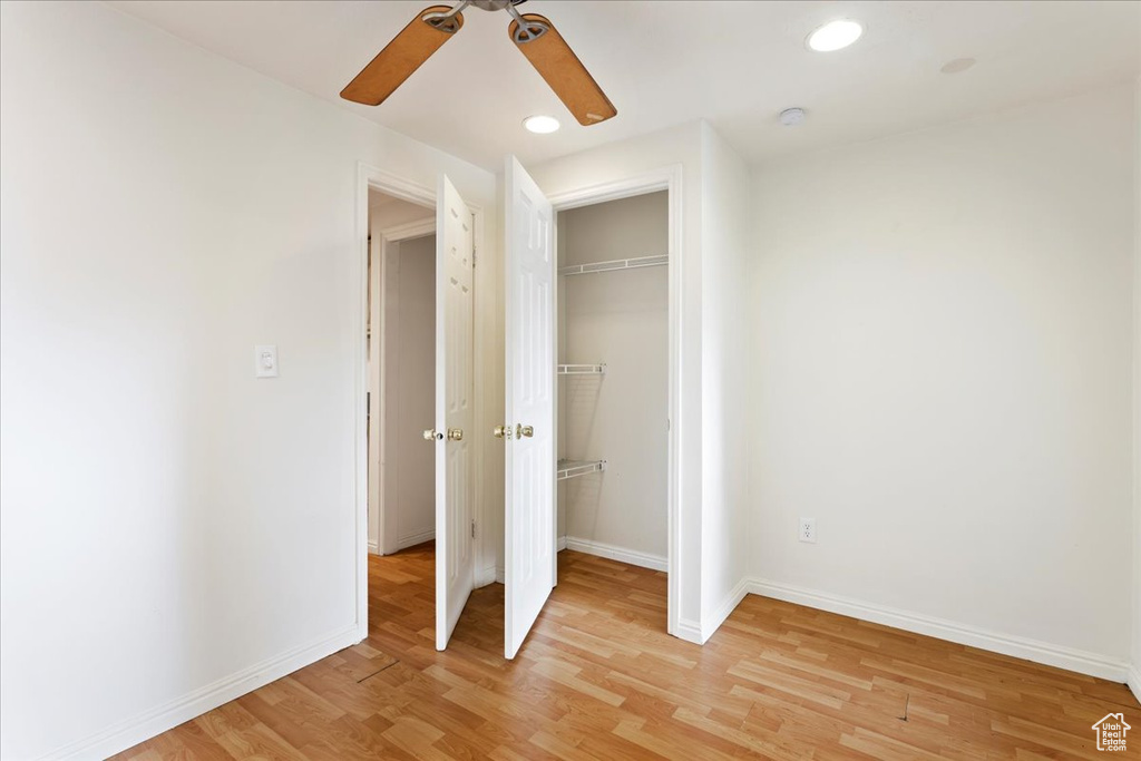 Unfurnished bedroom with ceiling fan, a closet, and light wood-type flooring