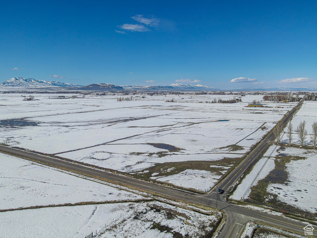 Snowy aerial view with a mountain view and a rural view
