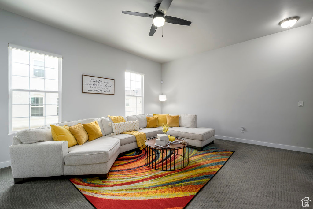 Carpeted living room with plenty of natural light and ceiling fan