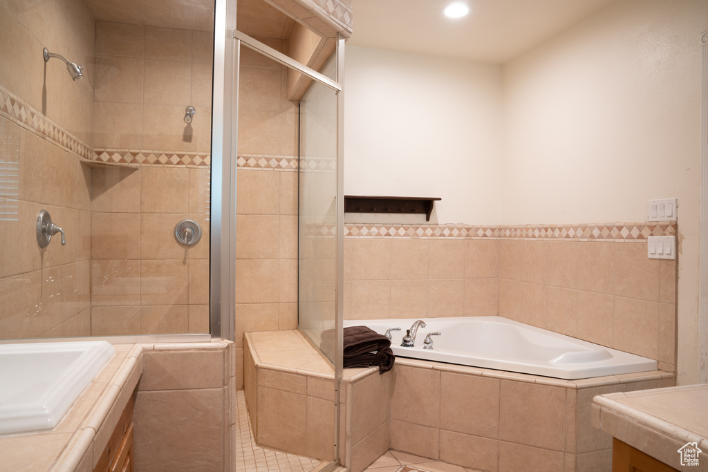 Bathroom featuring vanity, independent shower and bath, tile walls, and tile floors