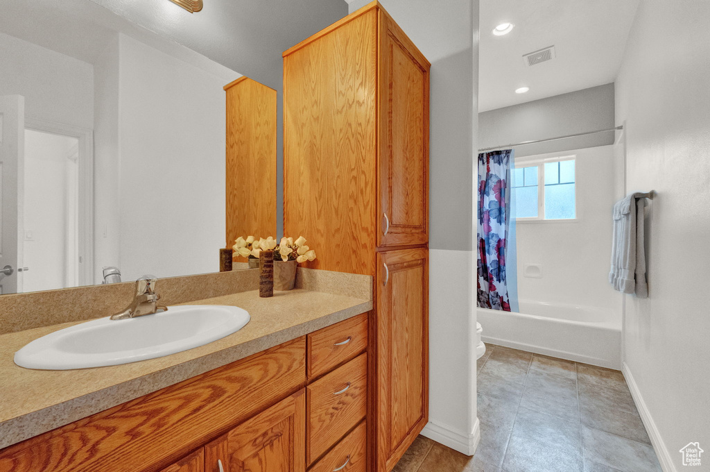 Full bathroom featuring large vanity, shower / bathtub combination with curtain, tile flooring, and toilet