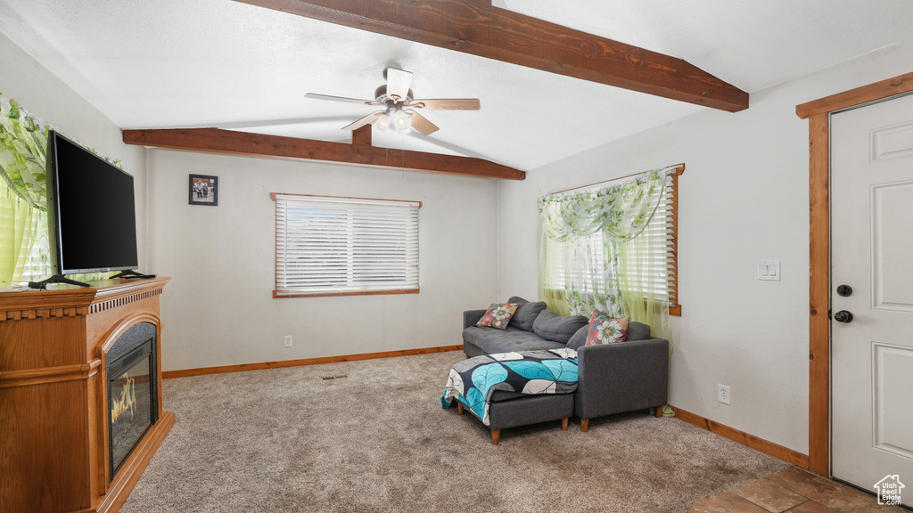 Living room with lofted ceiling with beams, ceiling fan, and light carpet