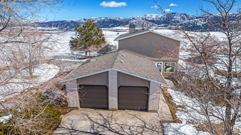 Snow covered garage with a mountain view