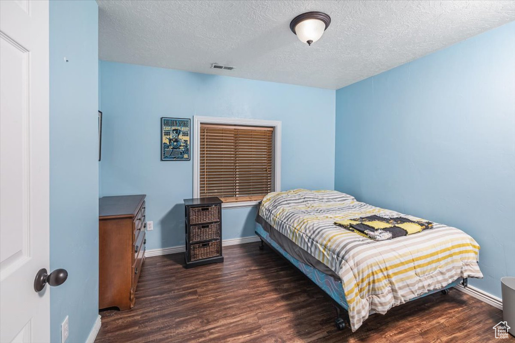 Bedroom featuring dark hardwood / wood-style floors and a textured ceiling