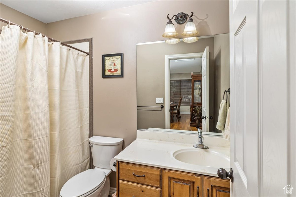 Bathroom featuring toilet, oversized vanity, and wood-type flooring