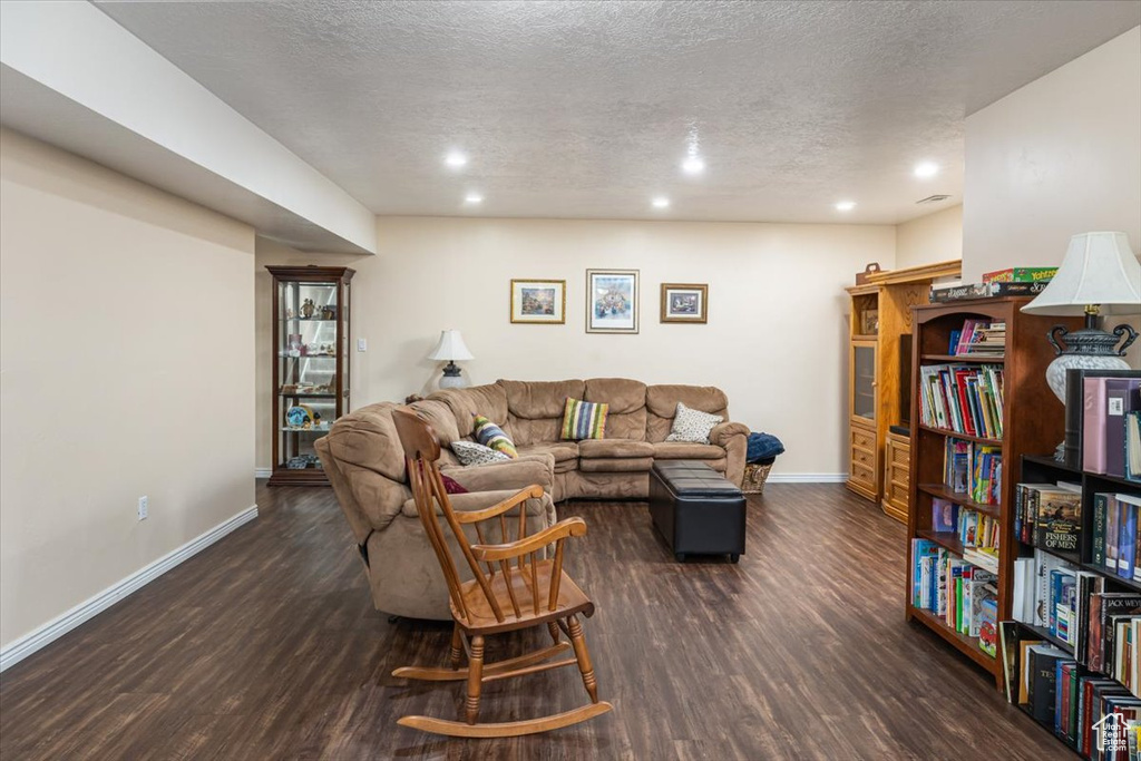 Living room with dark hardwood / wood-style floors and a textured ceiling