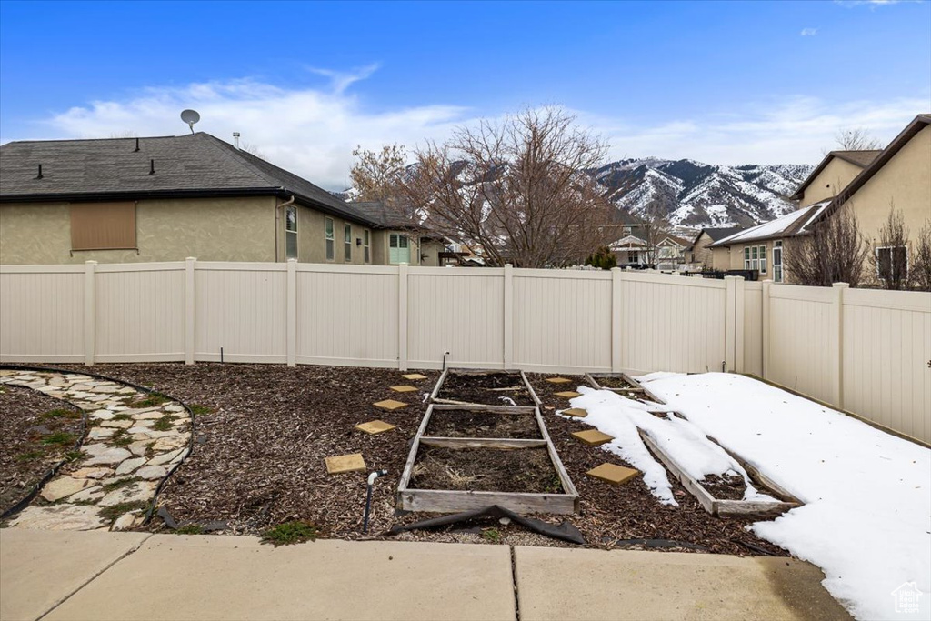 Yard layered in snow with a mountain view