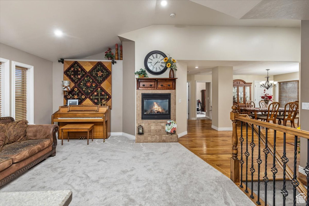 Carpeted living room featuring a chandelier and vaulted ceiling