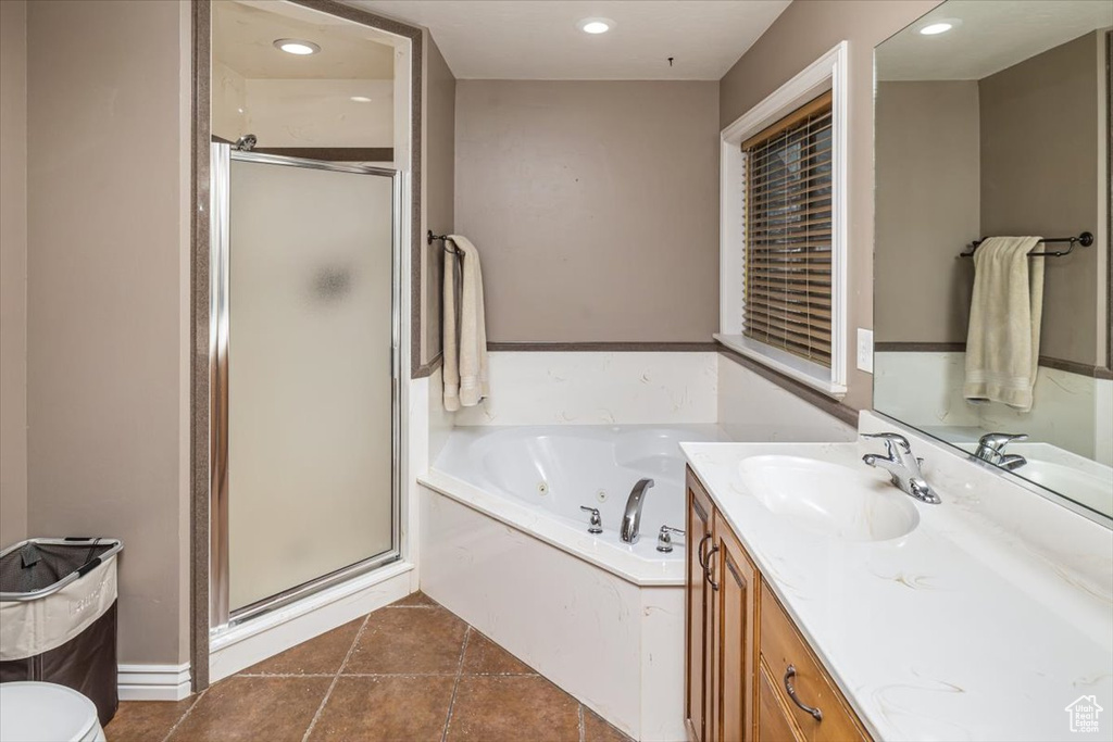 Full bathroom with vanity, tile floors, plus walk in shower, and toilet