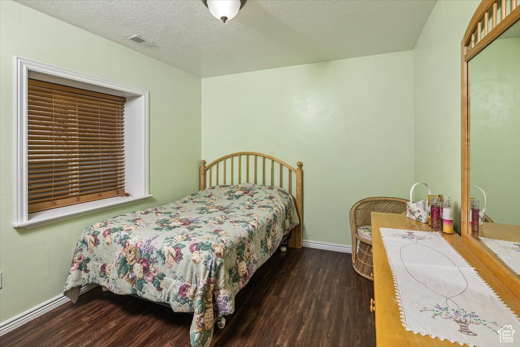 Bedroom featuring dark hardwood / wood-style flooring and a textured ceiling