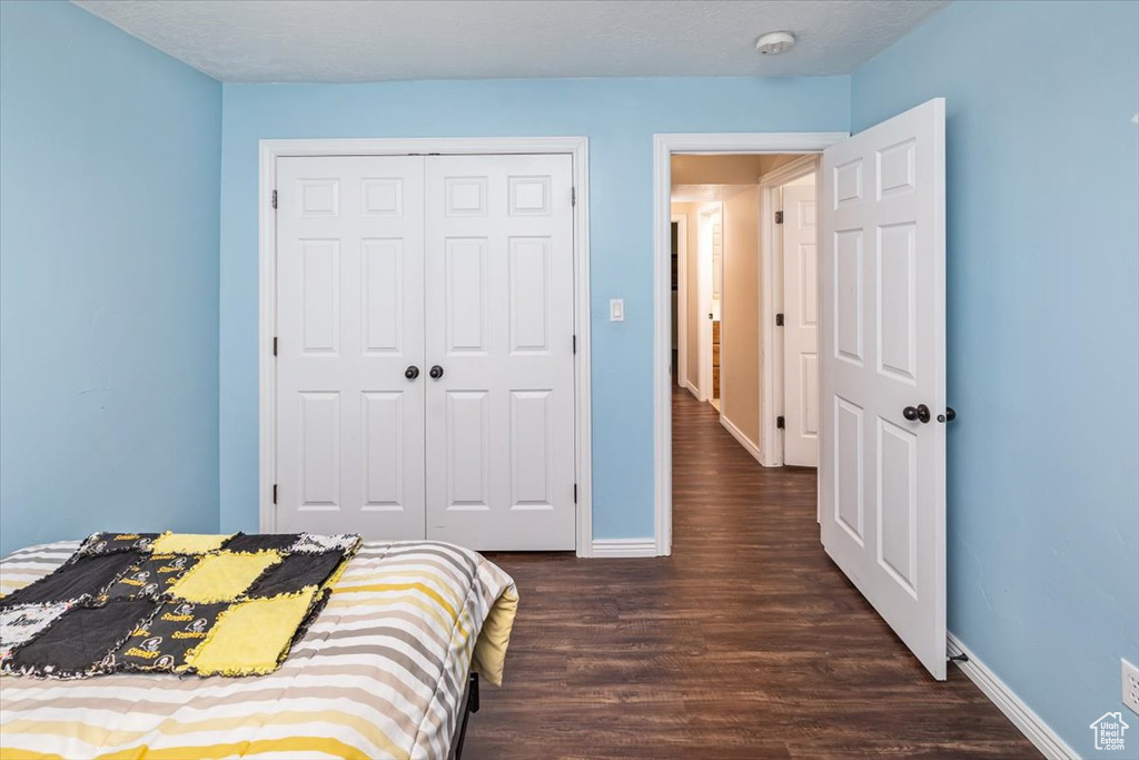 Bedroom featuring a closet and dark hardwood / wood-style flooring