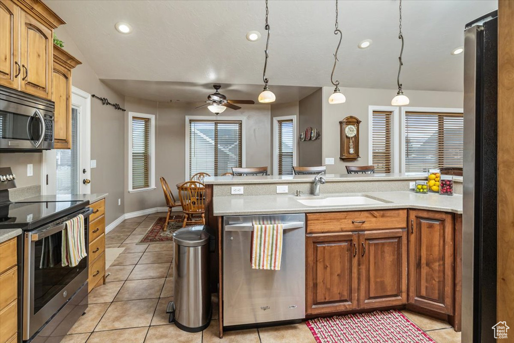 Kitchen featuring hanging light fixtures, sink, ceiling fan, and stainless steel appliances