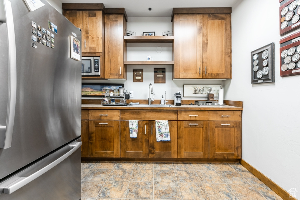 Kitchen with light tile floors, sink, and stainless steel appliances