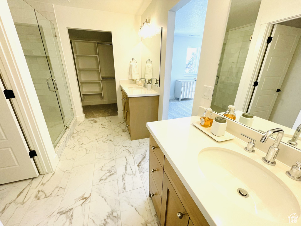 Bathroom featuring vanity, walk in shower, and tile flooring
