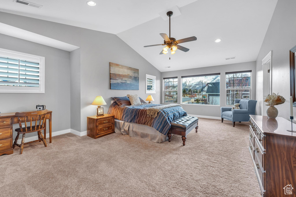 Bedroom with light colored carpet, ceiling fan, and multiple windows