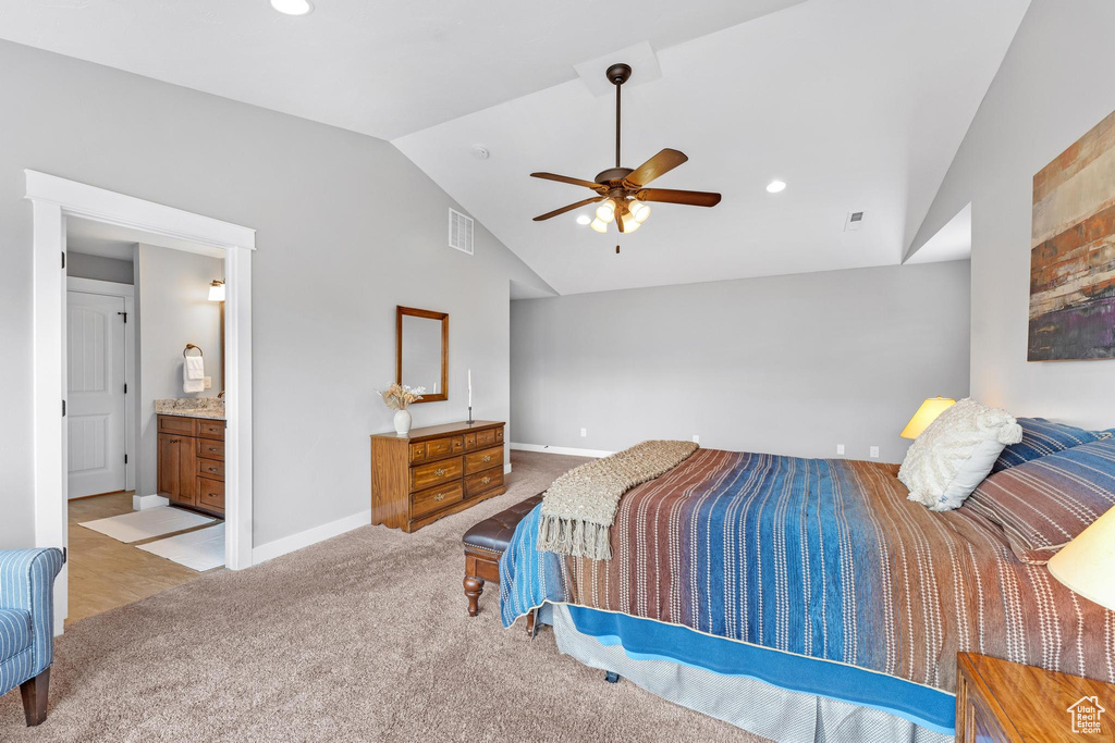 Carpeted bedroom featuring connected bathroom, ceiling fan, and lofted ceiling