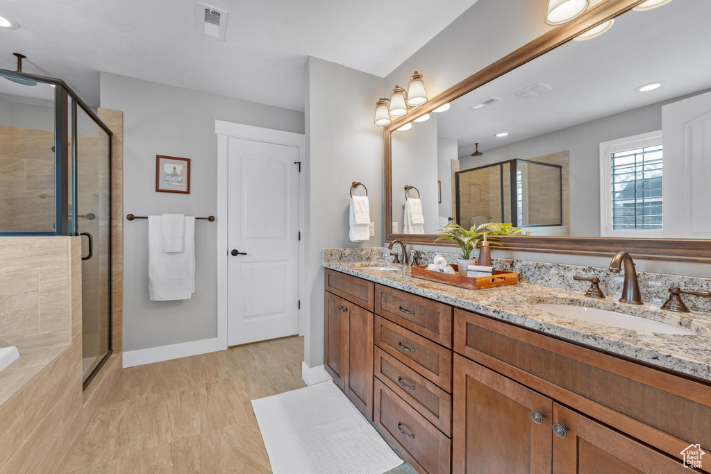 Bathroom with an enclosed shower, double sink, and vanity with extensive cabinet space