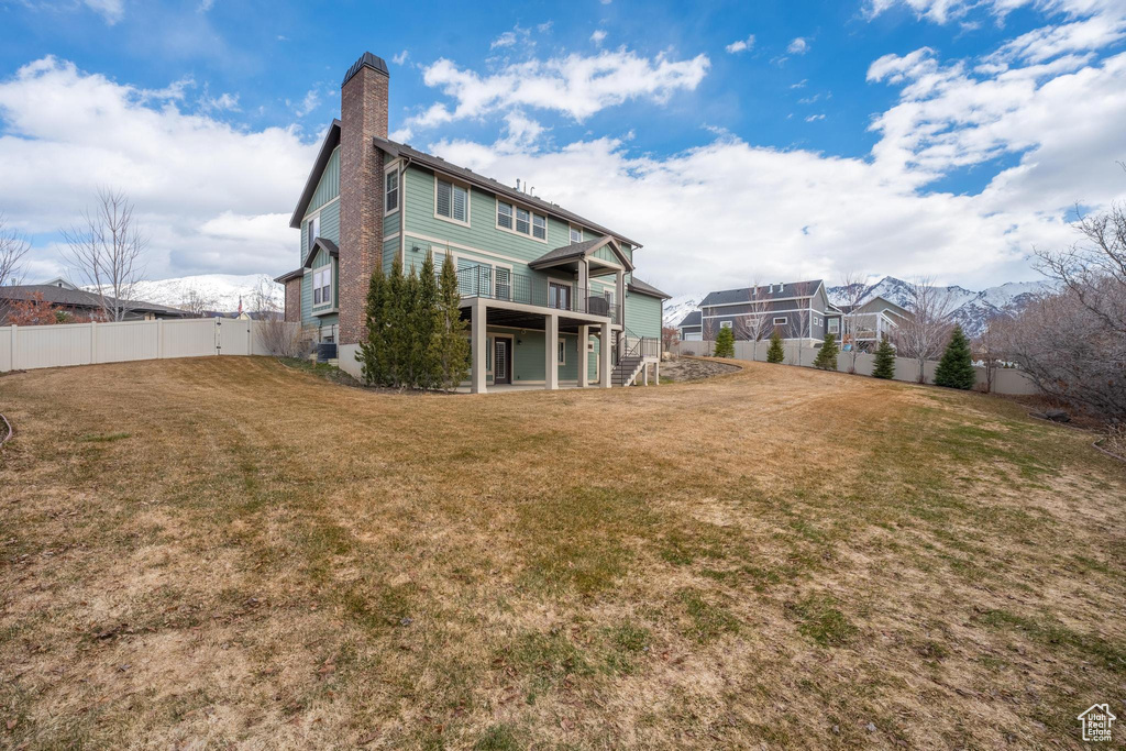 Back of property featuring a lawn and a mountain view