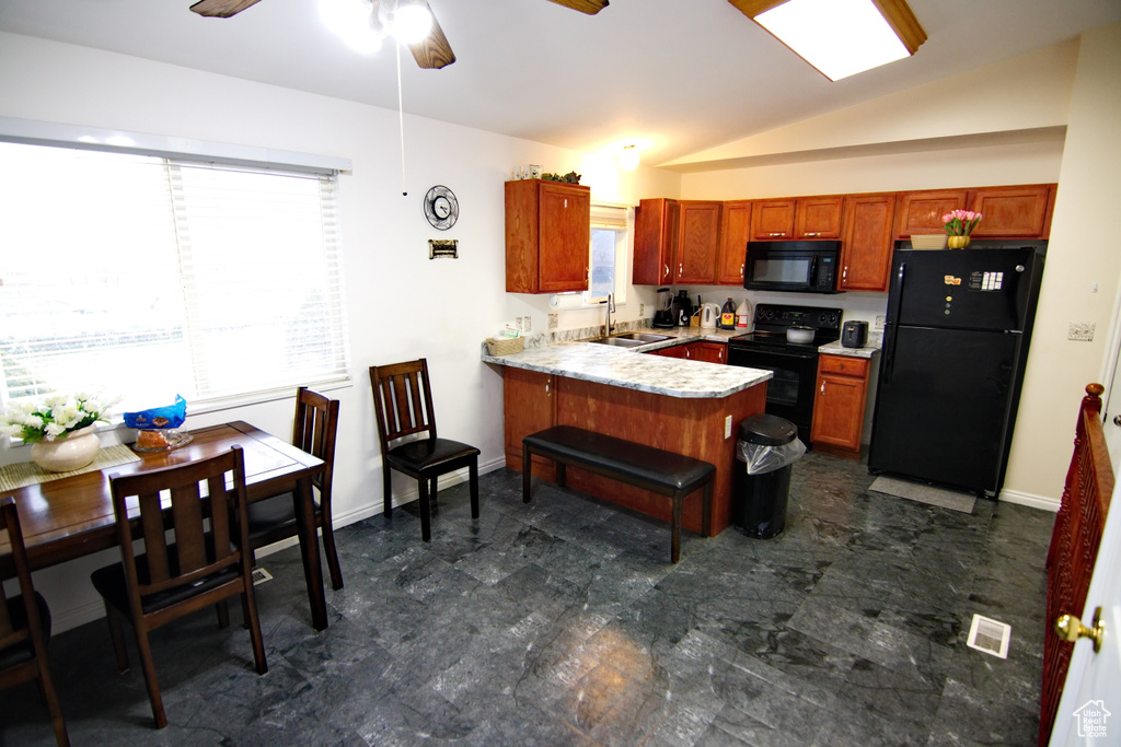 Kitchen with a healthy amount of sunlight, black appliances, ceiling fan, and dark tile flooring