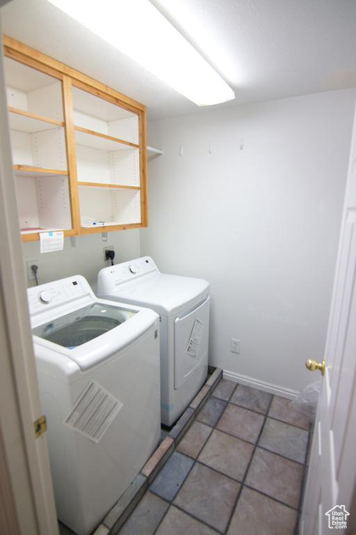 Washroom with separate washer and dryer, hookup for an electric dryer, and dark tile flooring