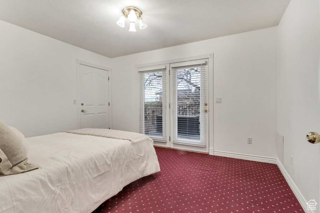 Bedroom with dark carpet and access to exterior