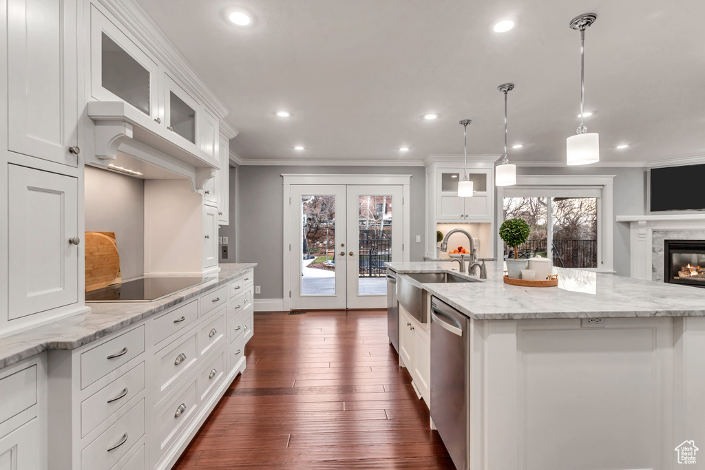 Kitchen featuring a high end fireplace, pendant lighting, white cabinets, french doors, and dark hardwood / wood-style floors
