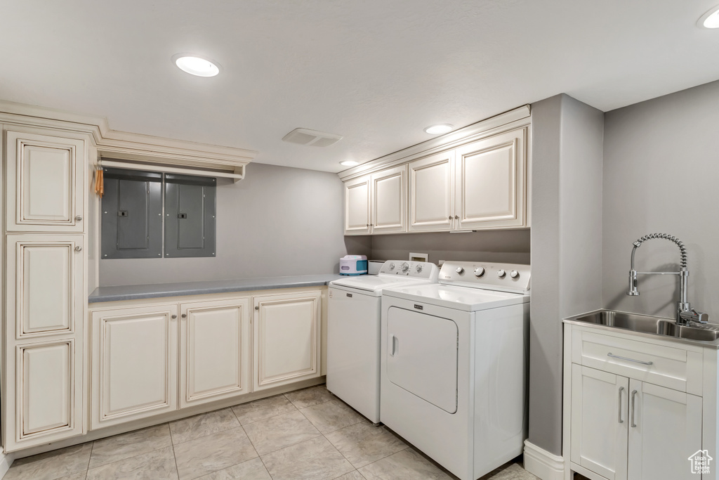 Laundry room with cabinets, sink, separate washer and dryer, and light tile floors