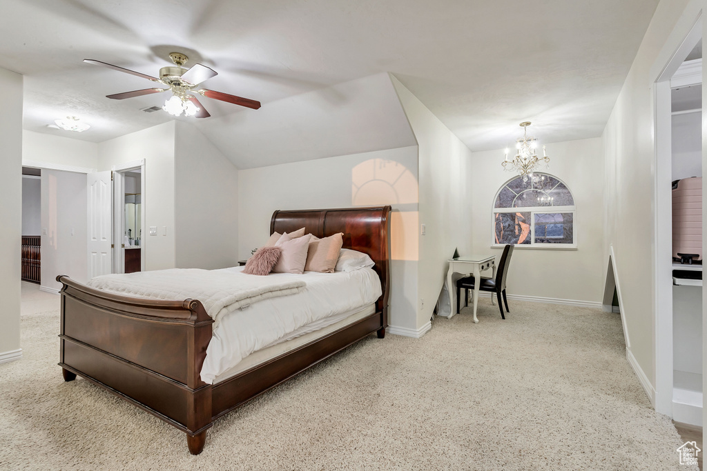 Bedroom featuring vaulted ceiling, ceiling fan with notable chandelier, and light colored carpet