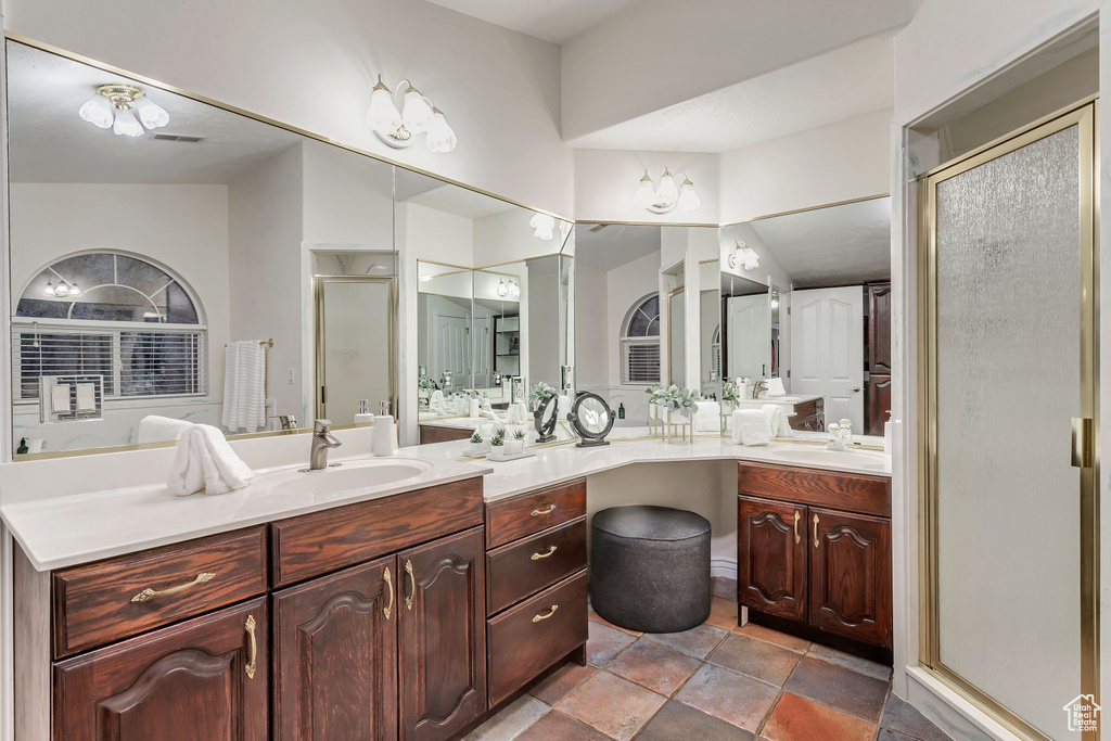 Bathroom featuring dual bowl vanity, tile flooring, and lofted ceiling