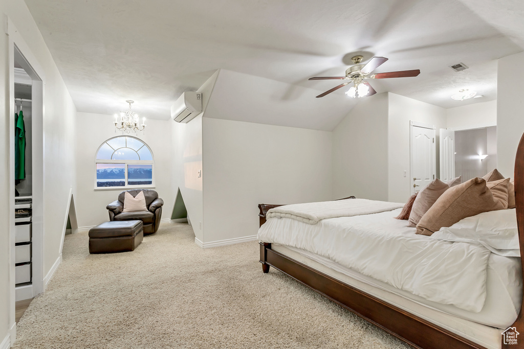 Carpeted bedroom featuring ceiling fan with notable chandelier, a closet, and a wall mounted air conditioner