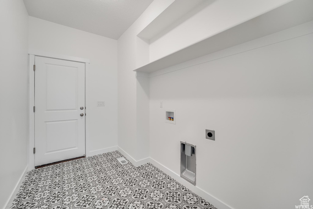 Washroom featuring light tile floors, electric dryer hookup, and washer hookup