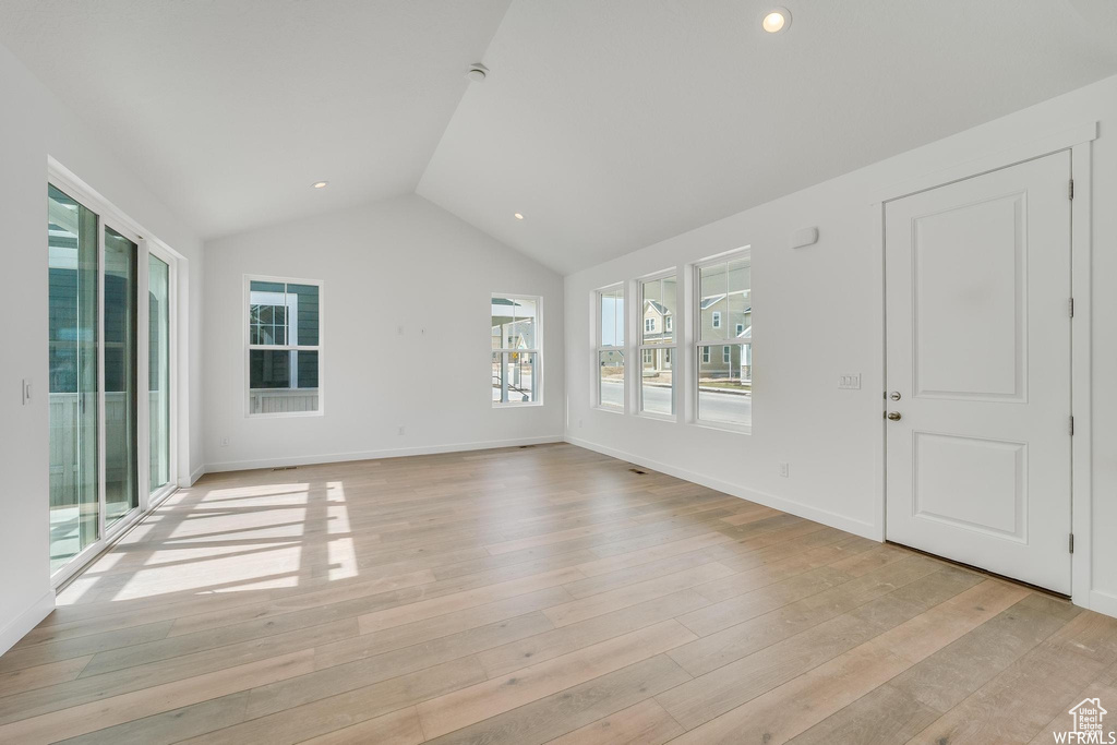 Unfurnished room featuring light hardwood / wood-style flooring and lofted ceiling