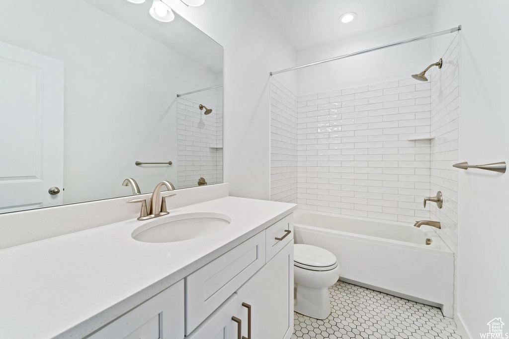 Full bathroom featuring tiled shower / bath, vanity, tile flooring, and toilet