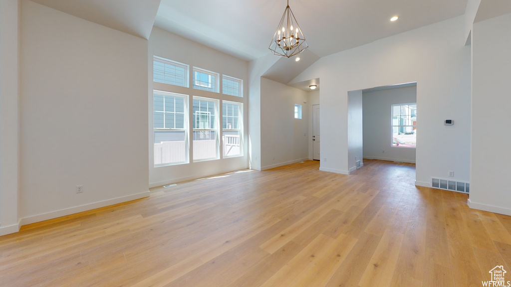 Empty room with an inviting chandelier and light hardwood / wood-style floors