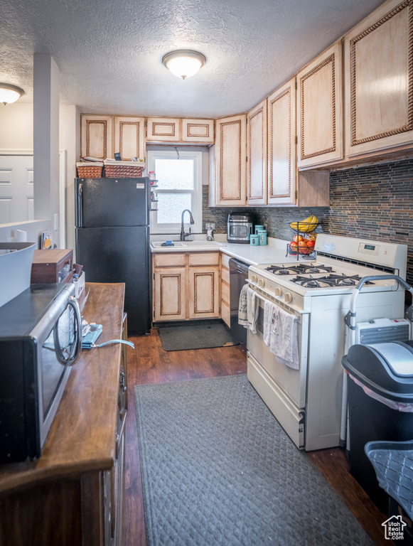 Kitchen with dark hardwood / wood-style flooring, light brown cabinets, tasteful backsplash, sink, and black appliances